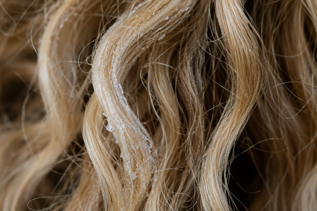 Close up of polymeric buildup on hair strands.