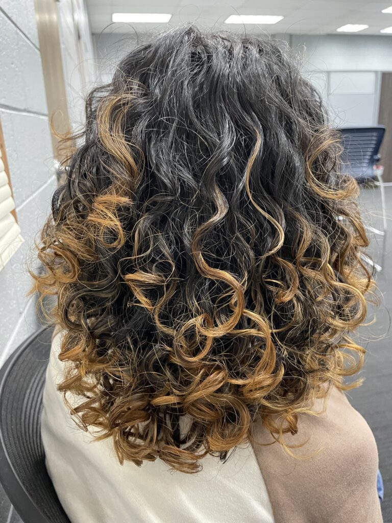 Back view of Author's daughter's looser, caramel-highlighted curls styled with Innersense I Create Hold gel.