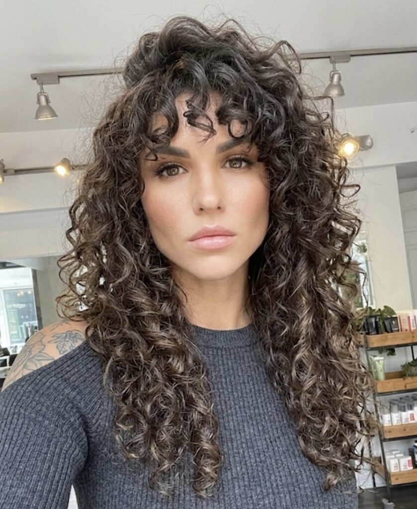 Woman with curly bangs.